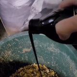 Pouring natural liquid supplement into horse feed